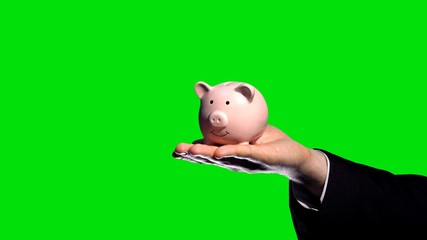 Businessman holding piggybank on hand, green screen, chroma key background