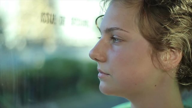 Young woman looking out the window.