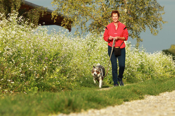 Woman walking her dog in summer