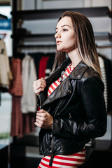 The young pretty woman choosing, trying and buys dresses at shop clothing. Banner for online store clothing.