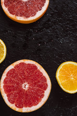 Delicious various types fresh cut of citrus fruit  on dark background.  Healthy eating, dieting.