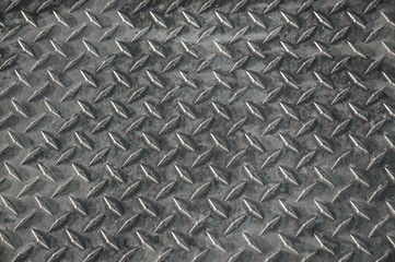 Abstract metal background with repeating diamond pattern.