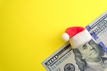 In the New Year without financial debt. Red Santa Claus hat on Franklin's head on one hundred...