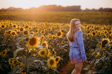 woman in a sunflower field at sunset