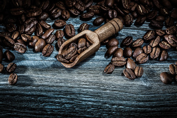 Wholegrain coffee crops in scoop on wooden board