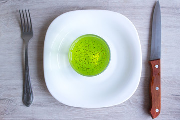 Fruit diet, cocktail with chia seeds. A fork and knife on a wooden background. Fast.