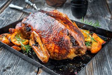 Traditional American Thanksgiving roasted turkey with fruits and potatoes as closeup on a board