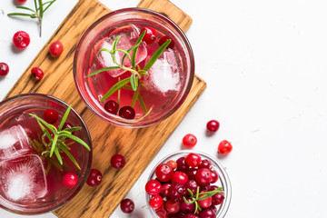 Cocktail with cranberry, vodka, rosemary and ice.