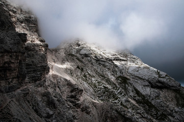 suggestive natural background of sun light rays on rock mountain wall in cloudy sky