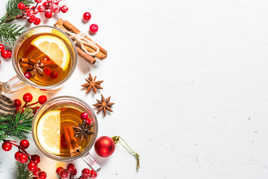 Winter hot tea with fruit, berries and spices on white table.