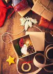 Christmas background. Open gift box with a tiny angel toy and a lot of christmas stuff with gift boxes.