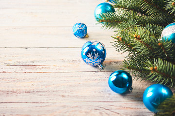 Christmas background. Fir tree and a lot of christmas blue baubles over white wooden board