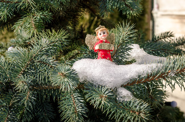 Winter angel figure red new year in the snow on the Christmas tree concept