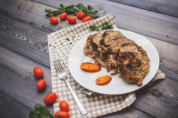A large piece of baked meat Still life on a light wooden table.
