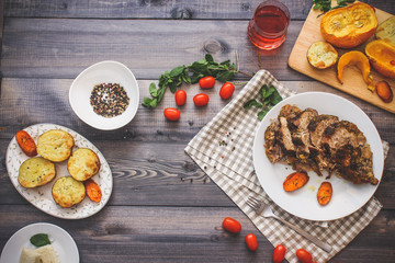 A large piece of baked meat Still life on a light wooden table.