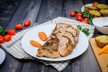 A large piece of baked meat Still life on a light wooden table.