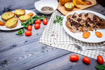 A large piece of baked meat Still life on a light wooden table.