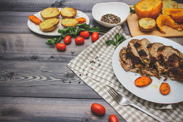 A large piece of baked meat Still life on a light wooden table.