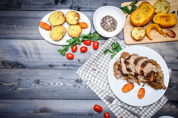 A large piece of baked meat Still life on a light wooden table.
