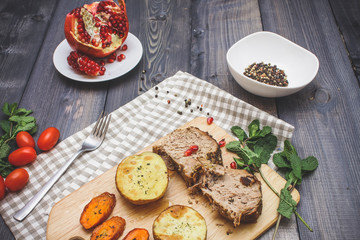 A large piece of baked meat Still life on a light wooden table.
