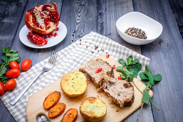 A large piece of baked meat Still life on a light wooden table.