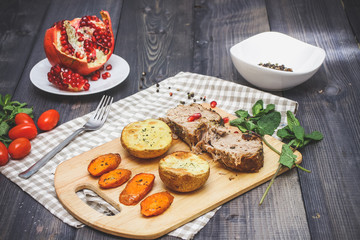 A large piece of baked meat Still life on a light wooden table.