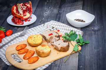 A large piece of baked meat Still life on a light wooden table.