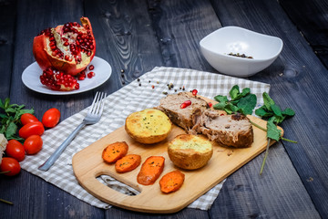 A large piece of baked meat Still life on a light wooden table.
