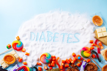 Sweets with sugar, flat lay frame on blue with word diabetes