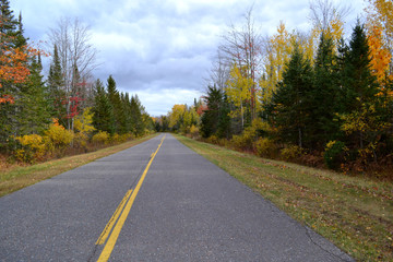 Old US Highway 2 in Michigan's Upper Peninsula with beautiful autumn colors lining the road. 