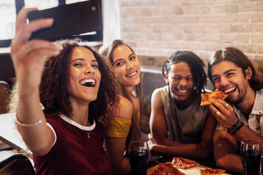 Mulltiracial friends taking selfie at pizza restaurant