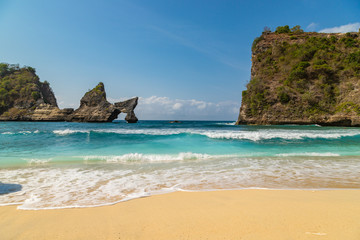 Fototapeta na wymiar Magnificent view of unique natural rocks and cliffs formation in beautiful beach known as Atuh Beach located in the east side of Nusa Penida Island, Bali, Indonesia.