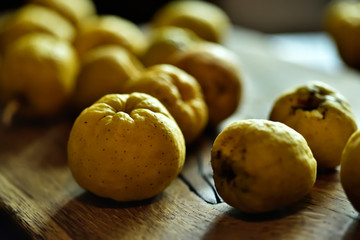 beaux fruits mûrs d'or jaune d'un coing sur une planche de bois sur un fond noir