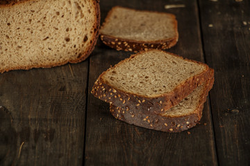 Bread, fresh homemade bread with wheat splash on a black wooden background. Fresh bread with wheat ear.