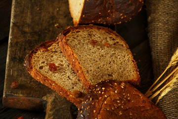 Bread, fresh homemade bread with wheat splash on a black wooden background. Fresh bread with wheat ear.