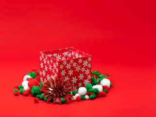 Christmas present box surrounded by fluffy pompoms