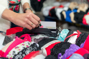 Obraz premium Client giving credit card for payment in underwear shop