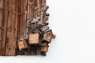 Several wooden bird boxes on a wooden wall
