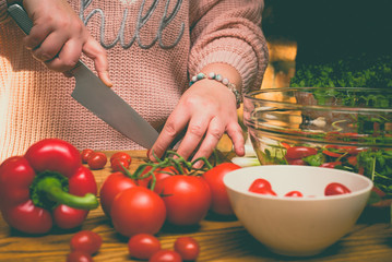 Beautiful plus size woman is making fresh salad in the kitchen