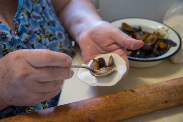 Senior lady making dumplings with stuffing