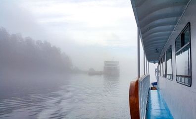 View of a cruise ship in a fog from the open deck of motorship.