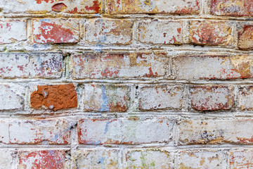 The texture of an old brick wall with traces of old rubbed paint_