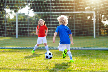 Kids play football. Child at soccer field.