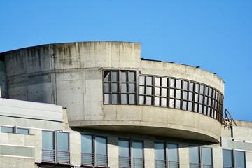 Fragment of a facade of a building with windows and balconies. Modern home with many flats.