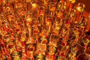 Bright abstract background of glass goblets with wine. Unusual bright abstract background of wine strings for decoration of a restaurant. Selective not deep focus, blur