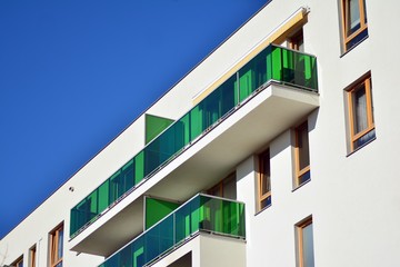 Fragment of a facade of a building with windows and balconies. Modern home with many flats.