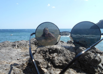beautiful landscape in double exposure, glasses on the shore of the blue sea on a summer day