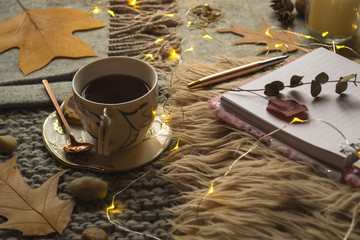 A cup of tea and decor on the table. Hygge style. Winter still life.