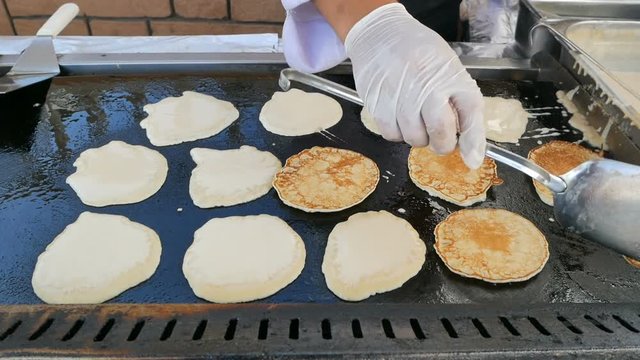 cooking pancakes on a large baking sheet in a restaurant