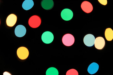Abstract blurry lights of Christmas and New Year illumination, pink, yellow, red and blue defocused round bokeh, background